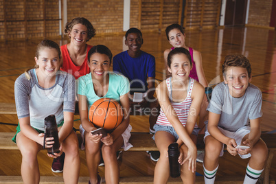 Portrait of smiling high school kids sitting on bench