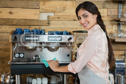 Portrait of waitress cleaning coffeemaker machine