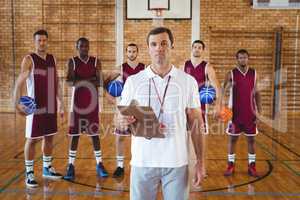 Confident coach and basketball player standing in the court