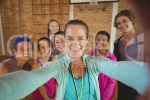 Female coach and high school kids taking a selfie