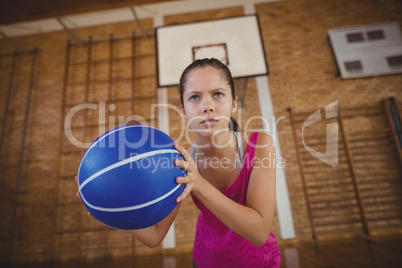 High school girl playing basketball in the court