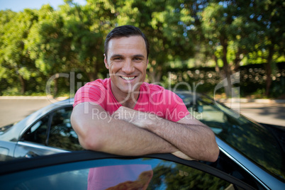 Smiling man leaning on car