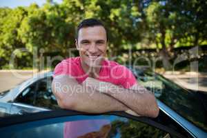Smiling man leaning on car