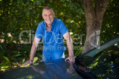 Portrait of senior man cleaning car