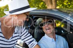 Senior woman looking at man sitting in car