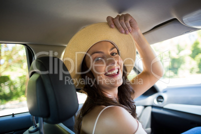 Cheerful young woman sitting in car