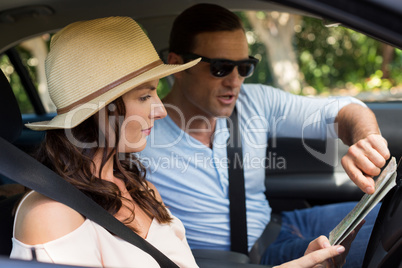 Couple reading map in car