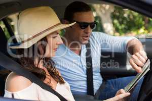 Couple reading map in car