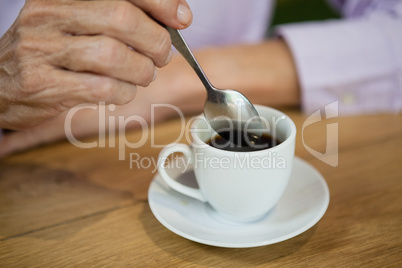 Close up of senior woman stirring coffee