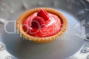 Close up of raspberry tart served in plate on table