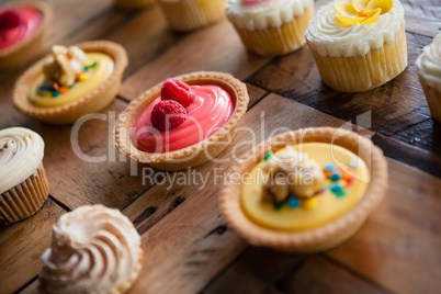 Close up of tart and cupcakes arranged on table