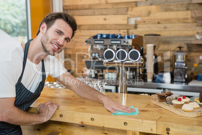 Portrait of waiter cleaning counter worktop
