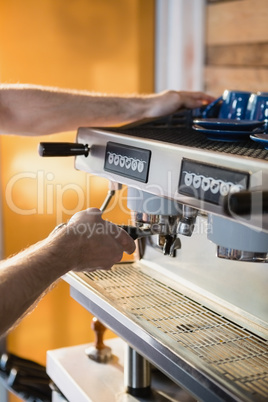 Waiter preparing coffee from coffee machine