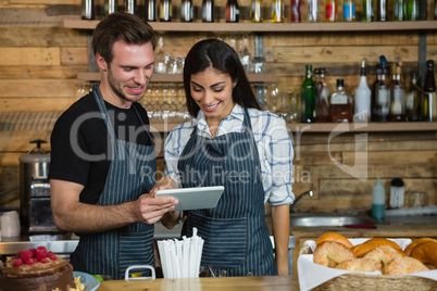 Waiter and waitresses using digital tablet at counter