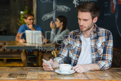 Man using mobile phone while having coffee