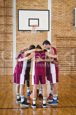 Basketball players forming a huddle
