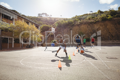 Basketball players practicing dribbling drill
