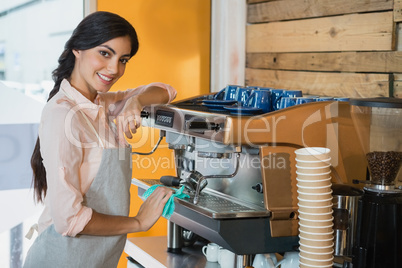 Portrait of waitress cleaning coffeemaker machine
