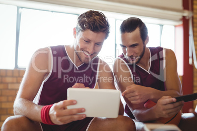 Basketball players talking while using digital tablet