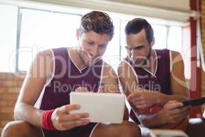 Basketball players talking while using digital tablet