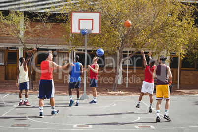 Basketball players practicing in basketball court