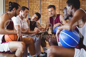 Coach explaining game plan to basketball players