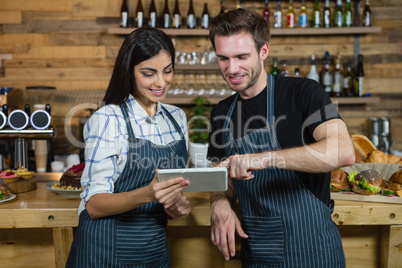 Waiter and waitresses using digital tablet at counter