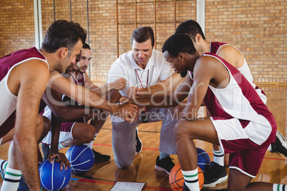 Basketball player and coach forming a handstack