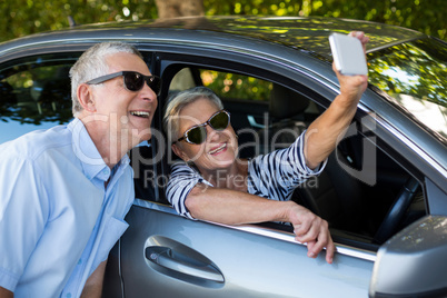Senior woman taking selfie with man