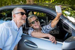 Senior woman taking selfie with man