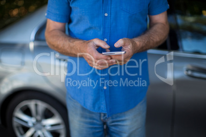 Man using mobile phone by car