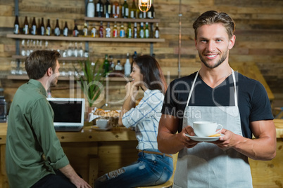 Waiter holding a cup of coffee