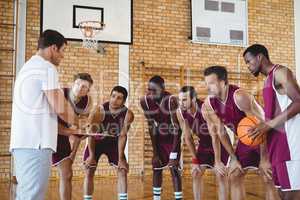 Coach explaining game plan to basketball players