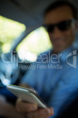 Man holding mobile phone in car