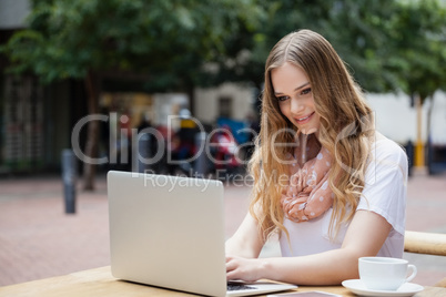 Woman using digital laptop while sitting at table