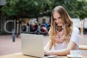 Woman using digital laptop while sitting at table