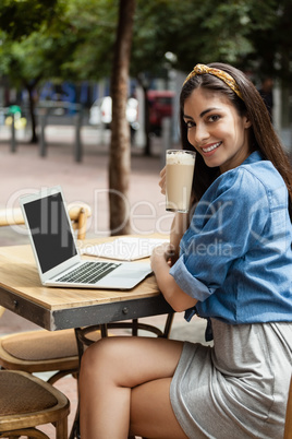 Portrait of smiling beautiful woman holding cold coffee