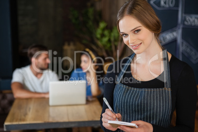 Portrait of owner writing on notepad