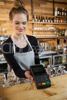 Smiling woman holding credit card reader