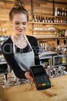 Smiling woman holding credit card reader