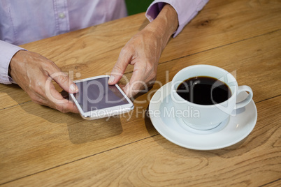 High angle view of senior woman using smart phone at cafe