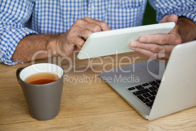 Midsection of senior man using digital tablet