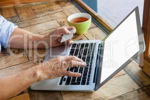 High angle view of  woman typing on digital laptop at table