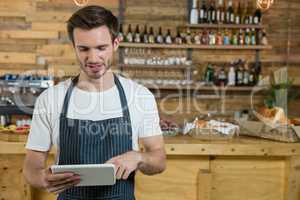 Waiter using digital tablet at counter