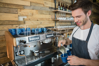 Waiter making coffee at counter