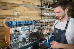 Waiter making coffee at counter