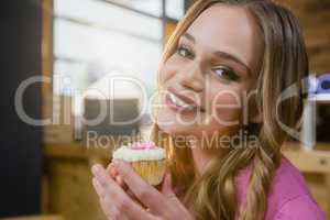 Portrait of beautiful woman holding cupcake