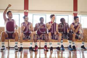 Excited basketball player sitting on bench