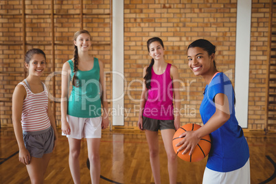 Portrait of smiling high school kids standing with basketball