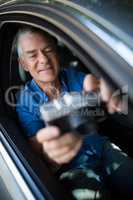 Senior man taking selfie with camera while sitting in car